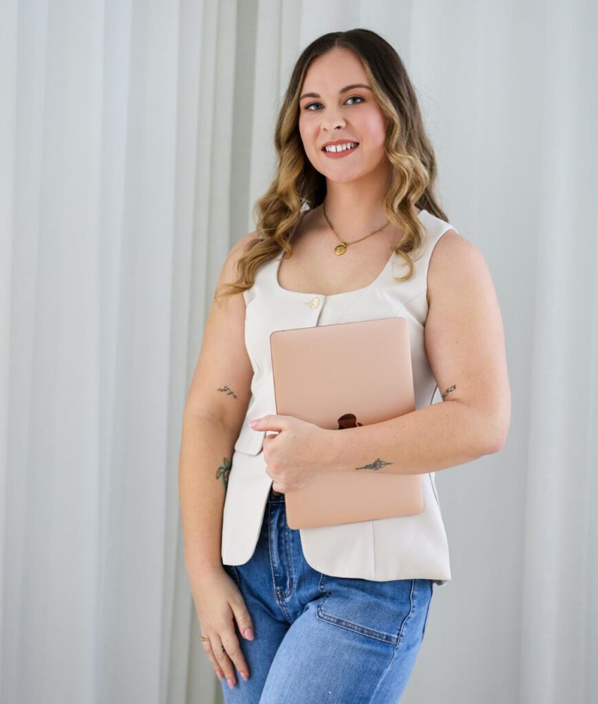 Shenae standing with her laptop, ready to help a small business get online